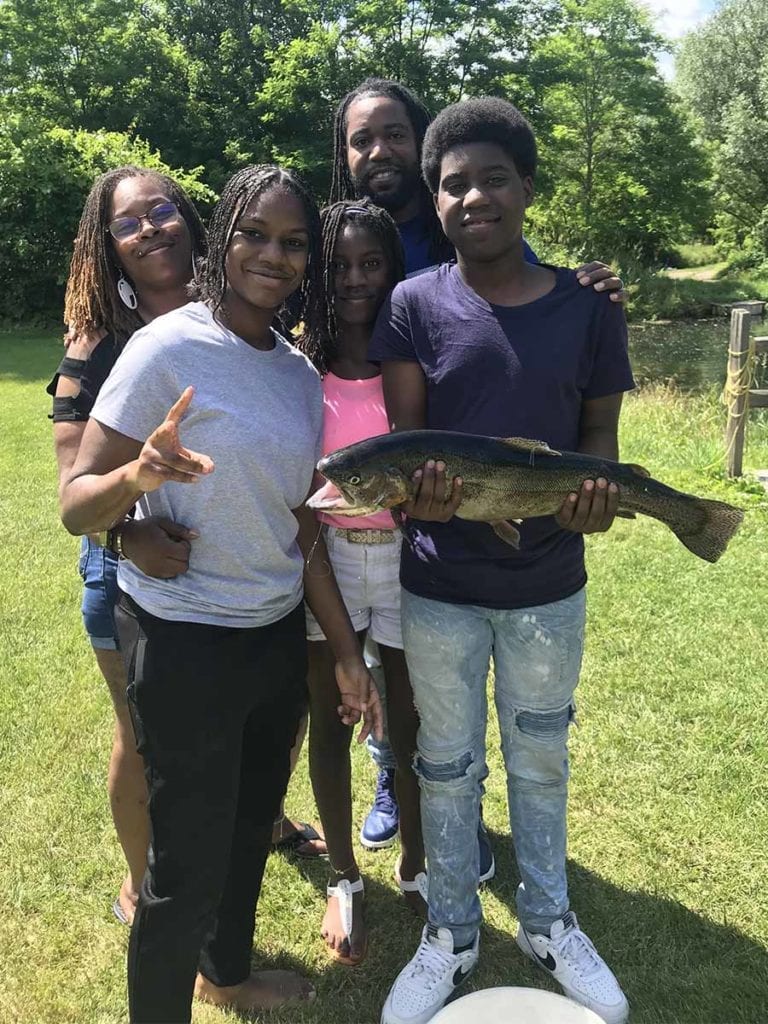 Happy family with teen holding a trout