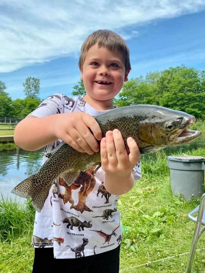 Proud smiling boy holds a trout